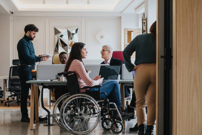 Employees of different ethnicities, ages, and abilities working together in an inclusive office environment.