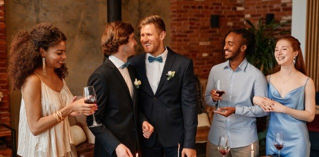Happy same-sex couple smiling together as they celebrate their marriage during a joyful wedding reception.